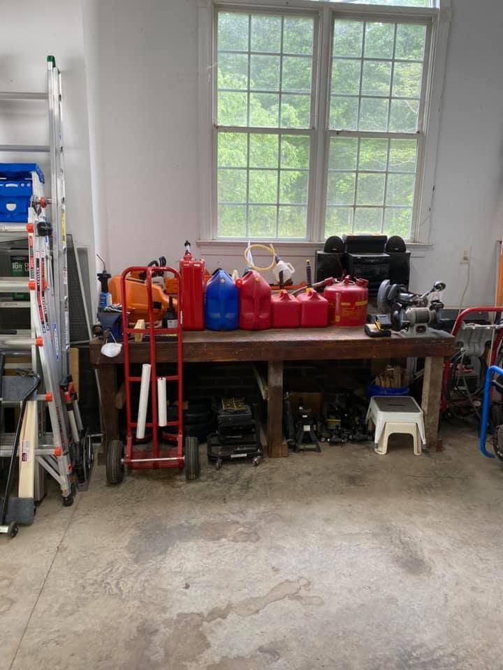 A garage filled with lots of tools and gas cans.