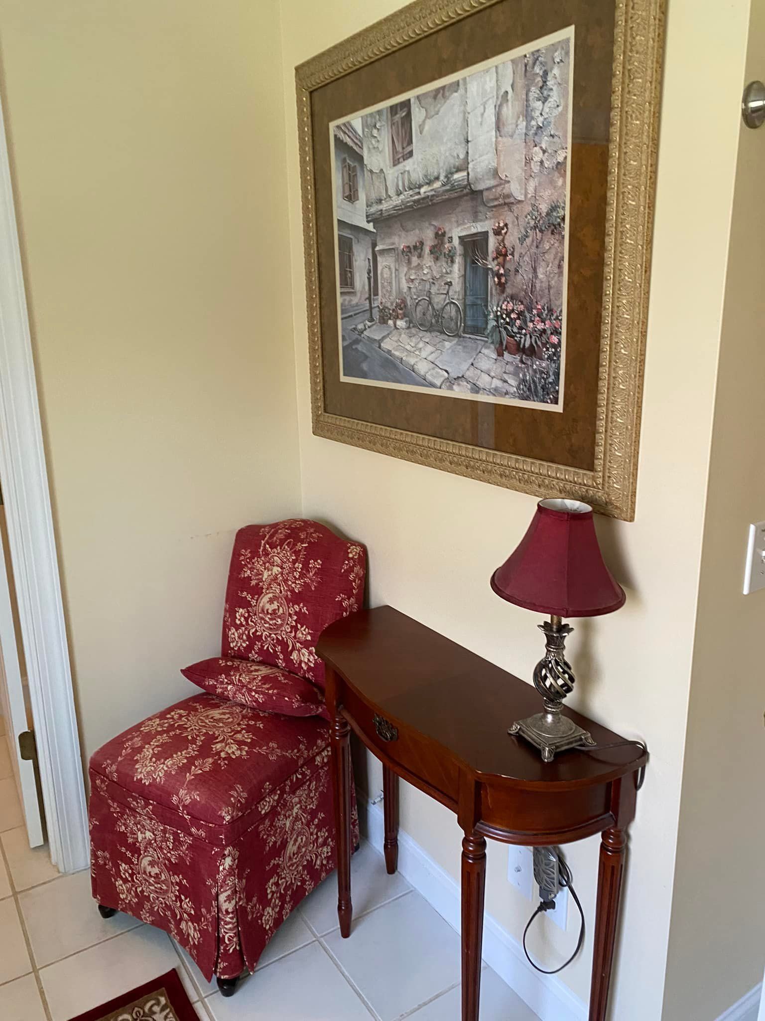 There is a picture on the wall above the chair and table.