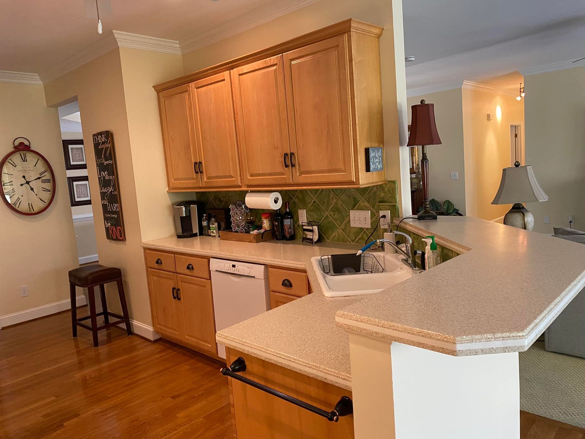 A kitchen with wooden cabinets and a clock on the wall