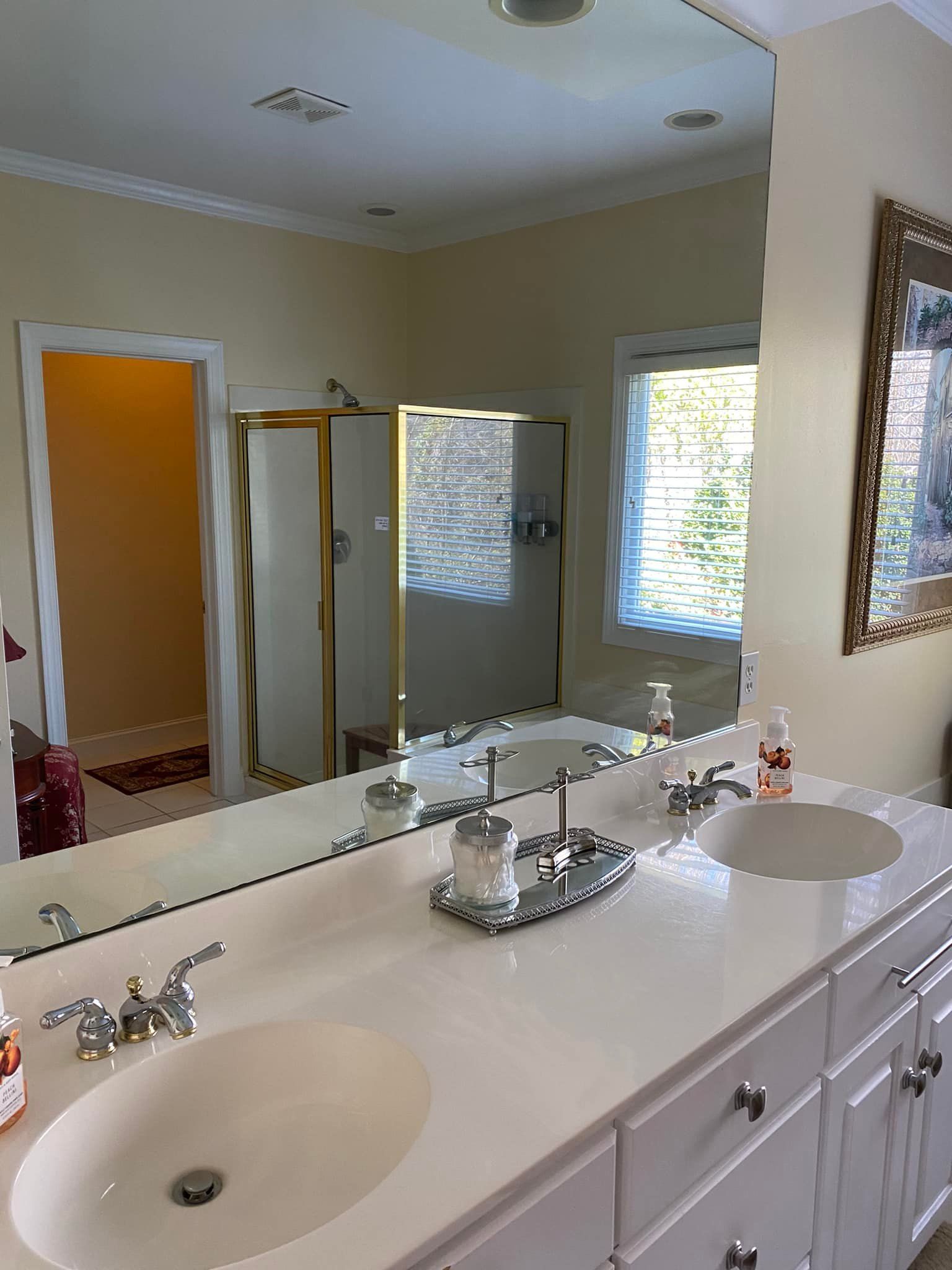 A bathroom with two sinks and a large mirror.