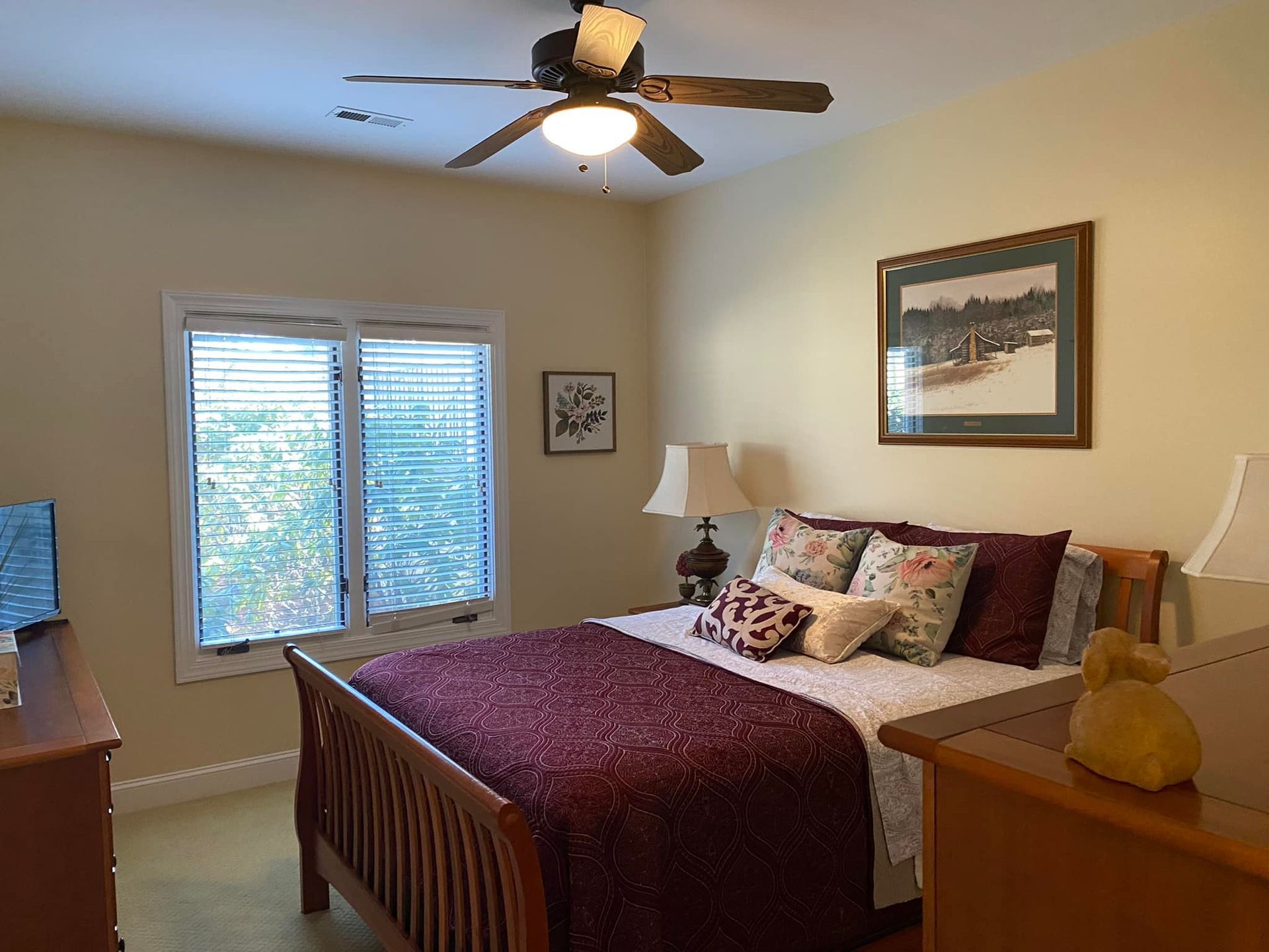 A bedroom with a large bed and a ceiling fan