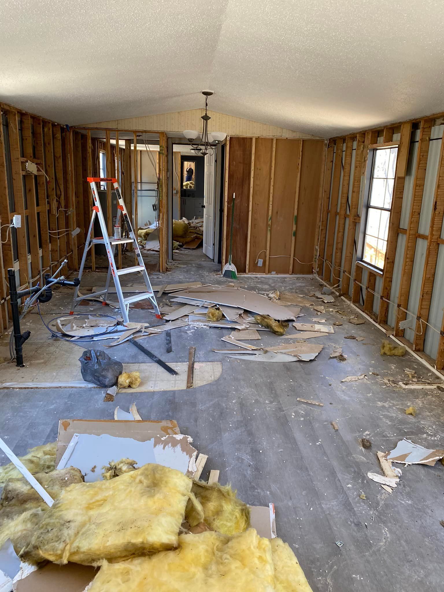 A room with a lot of junk in it and a ladder.