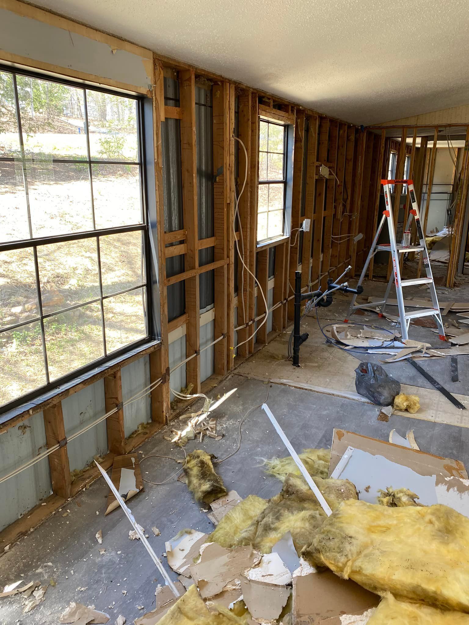 A room with a lot of windows and a ladder in it.