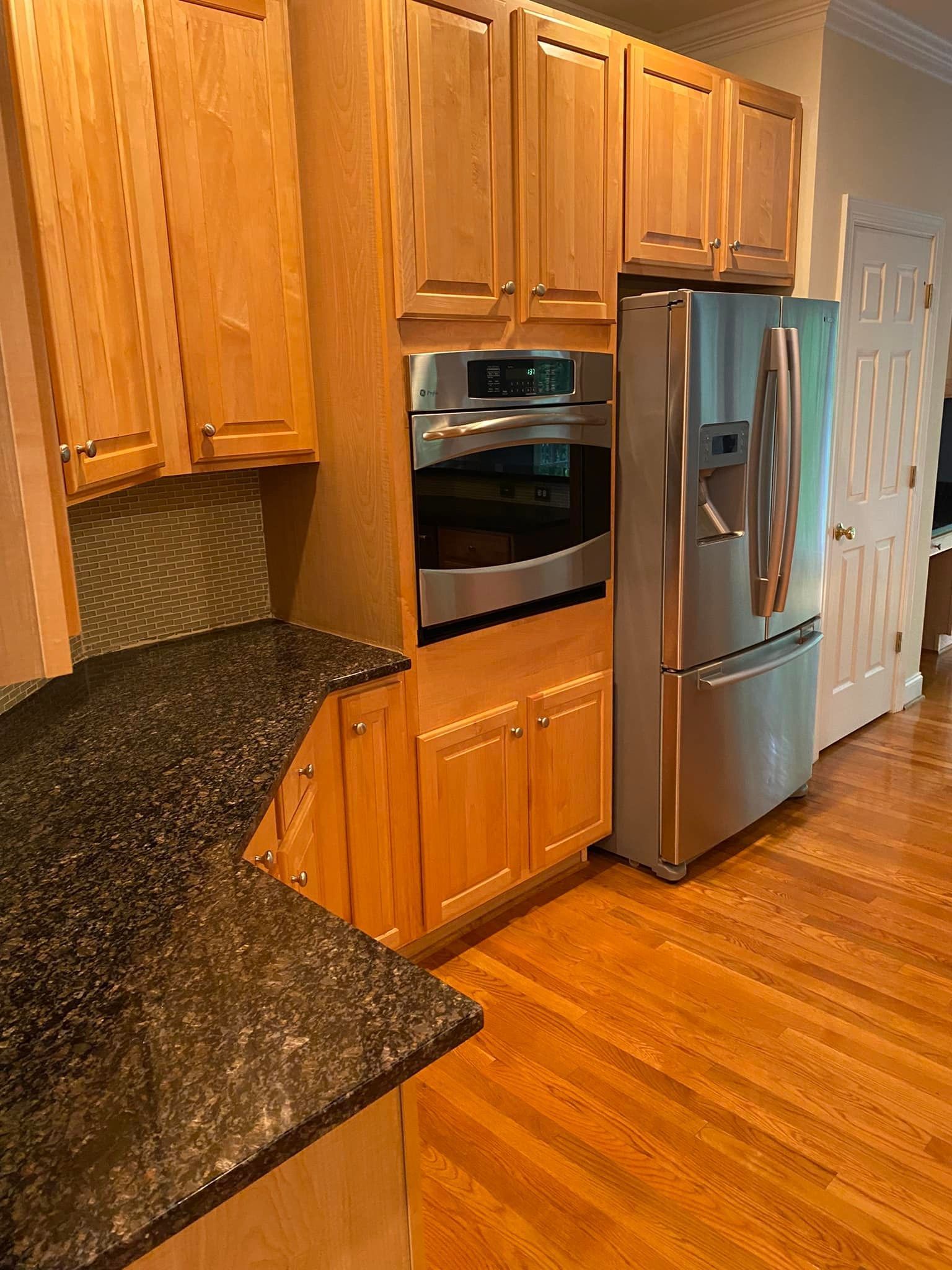 A kitchen with stainless steel appliances and wooden cabinets.