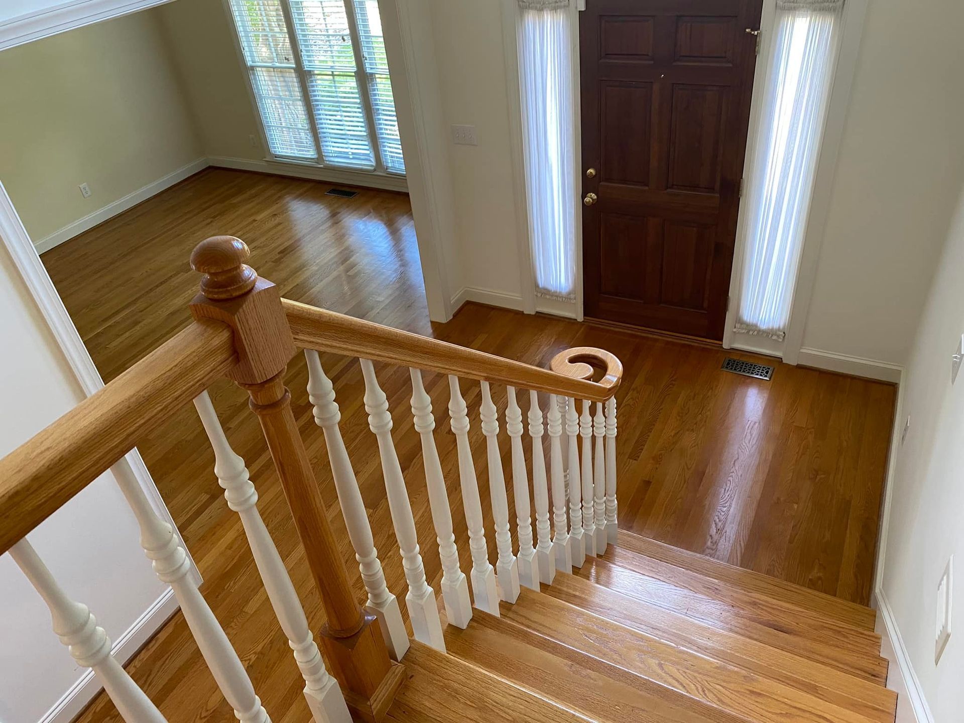 A wooden staircase with a white railing leading up to a wooden door.