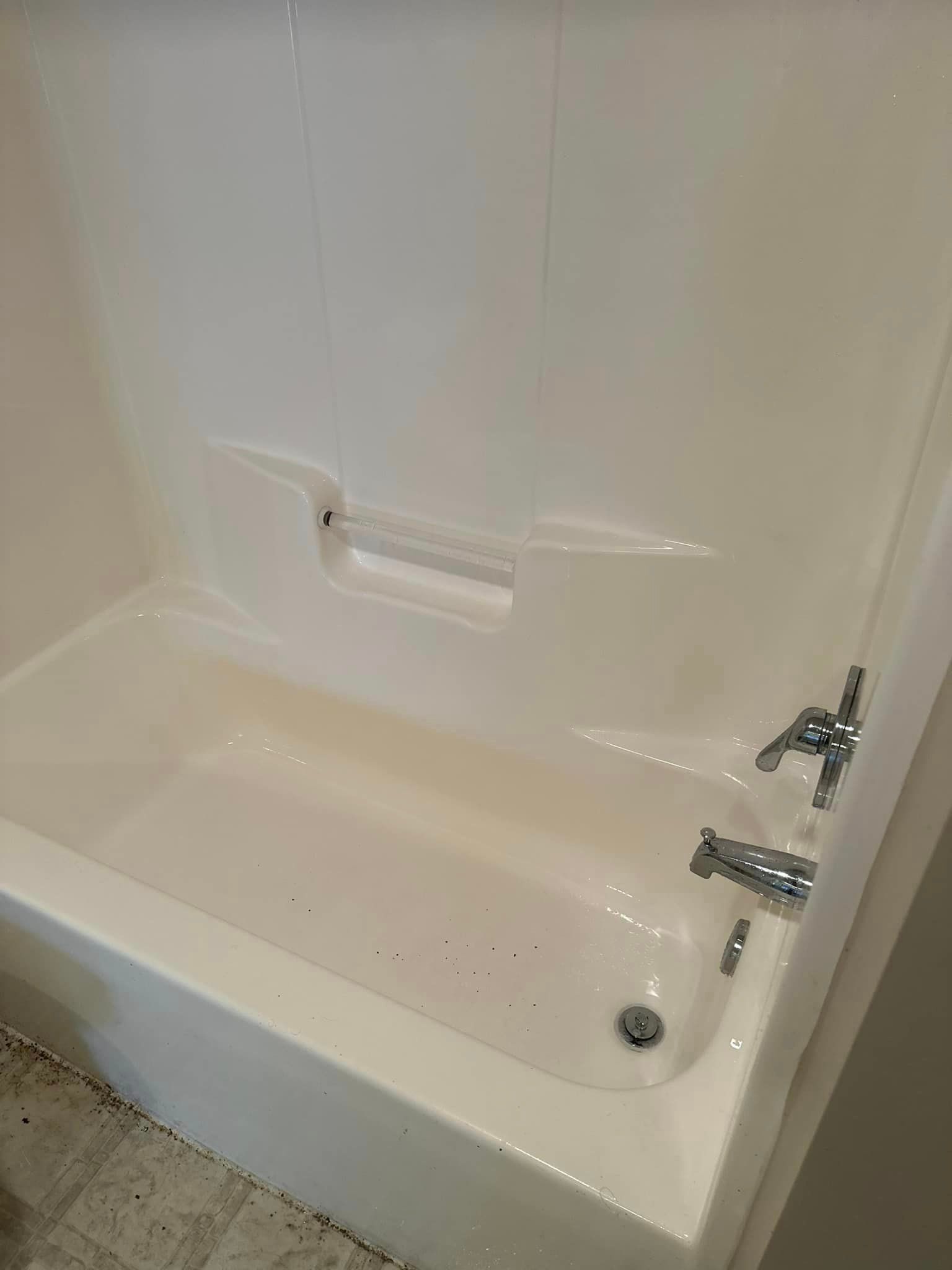 A white bathtub with a chrome faucet in a bathroom.