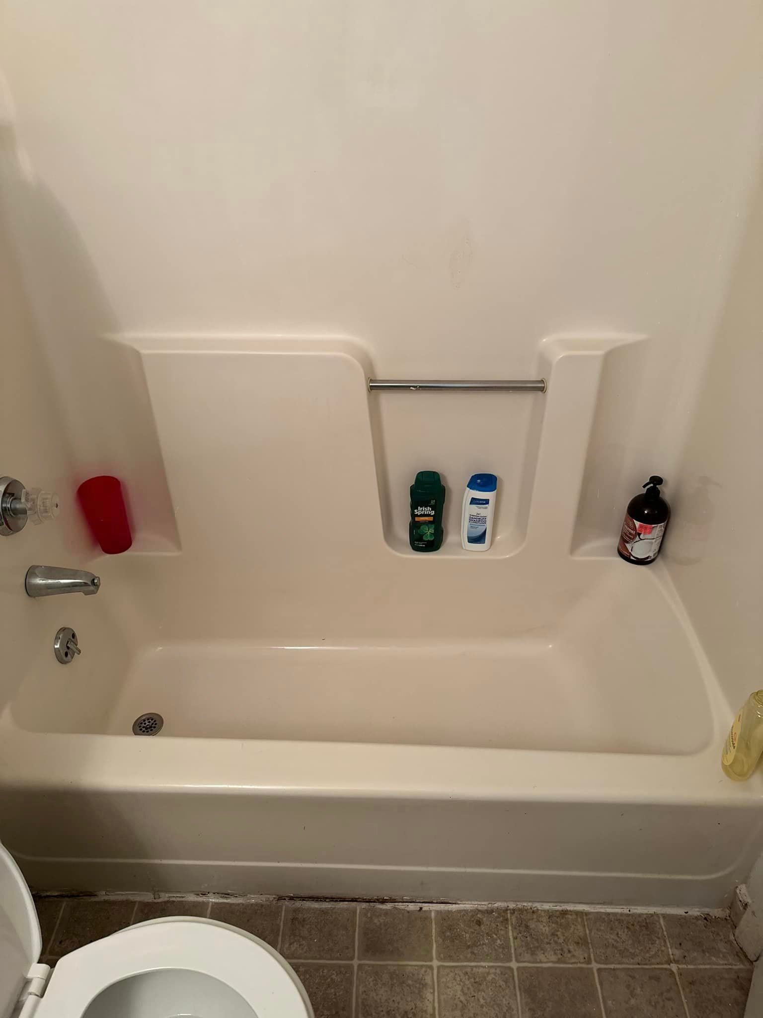 A bathroom with a bathtub , toilet and shower.