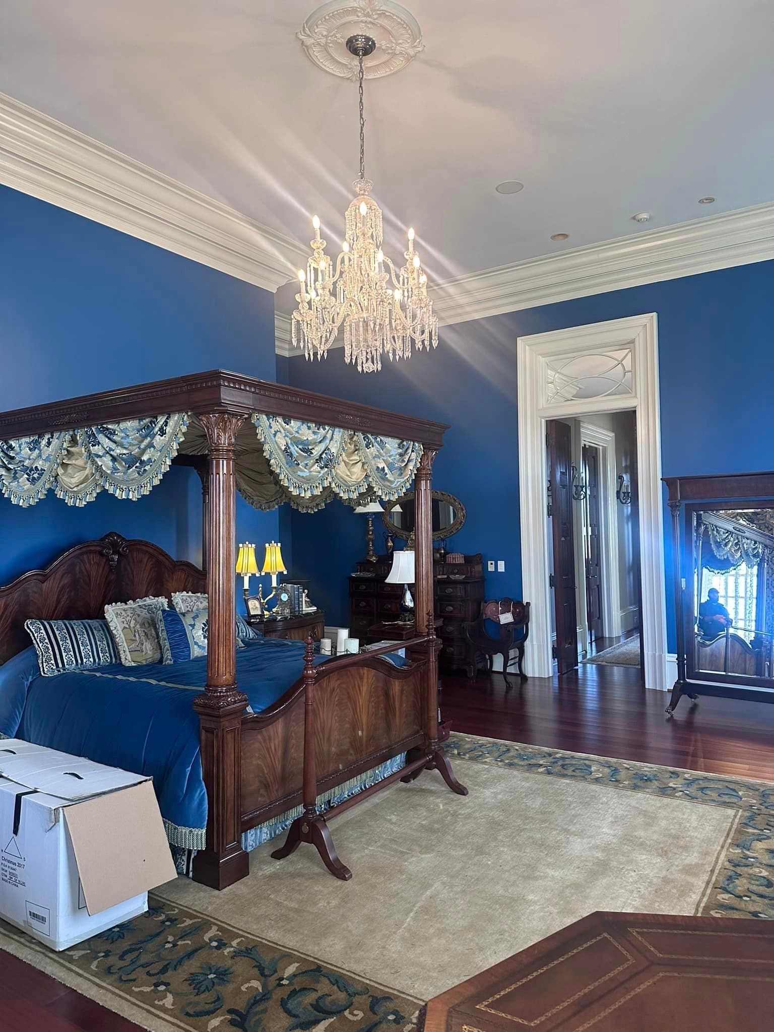 A bedroom with a canopy bed and a chandelier