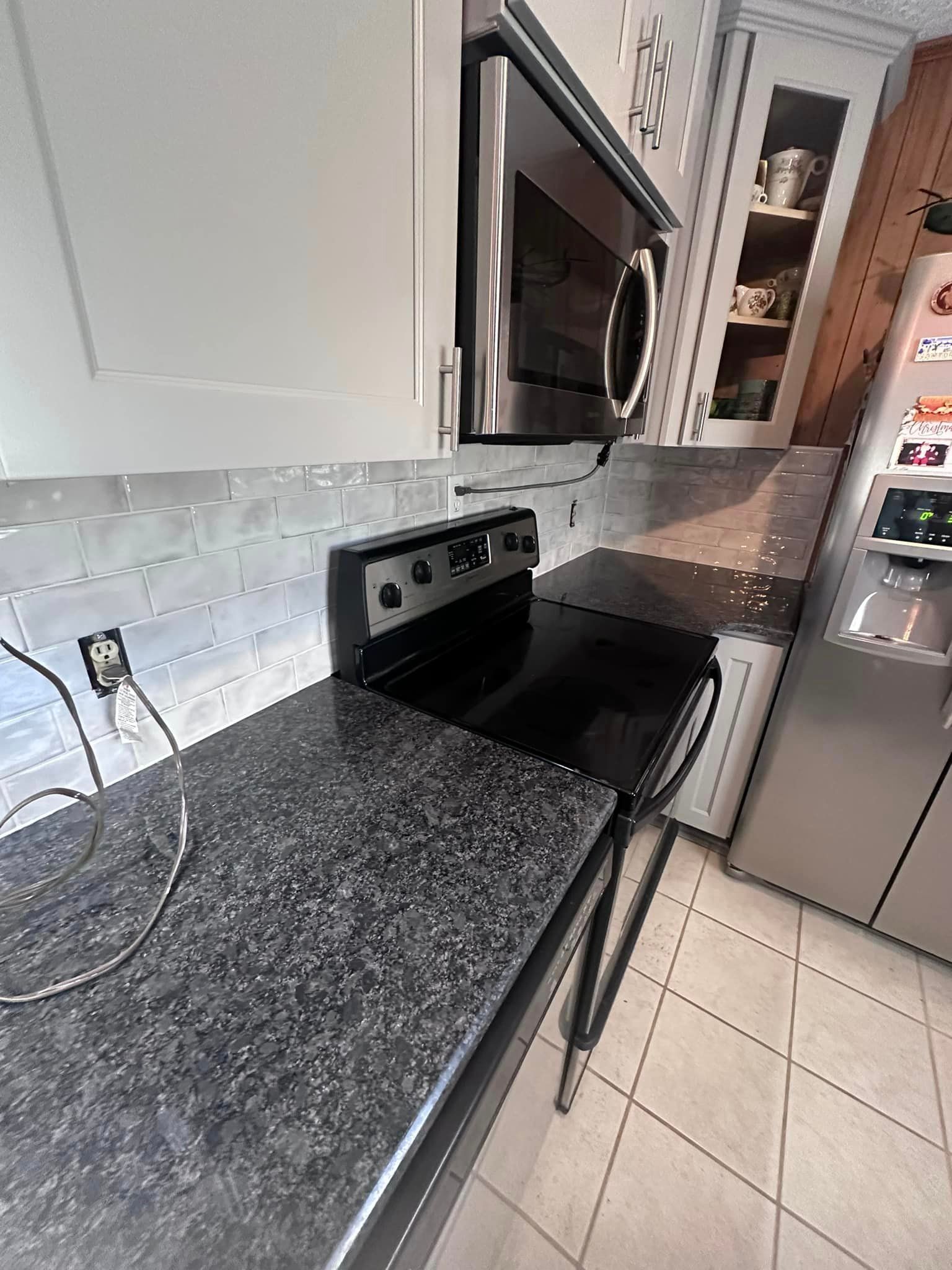 A kitchen with a stove , microwave and refrigerator.