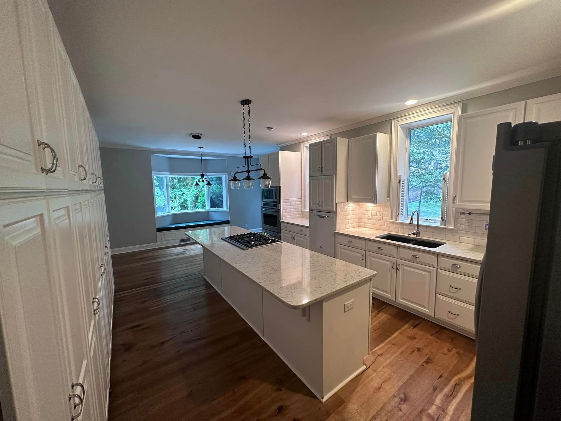 A kitchen with white cabinets and a large island in the middle.