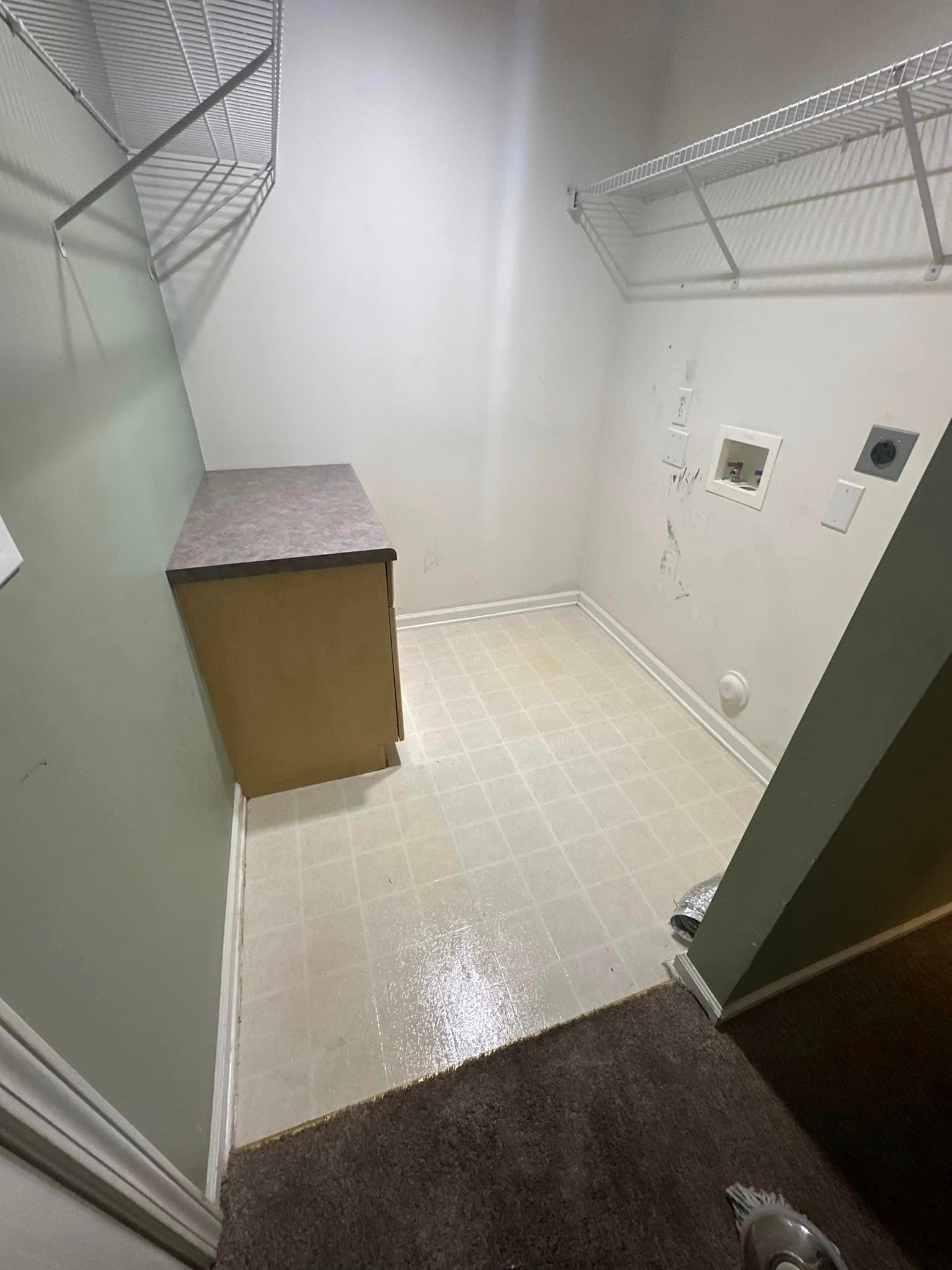 A laundry room with a washer and dryer and a shelf.