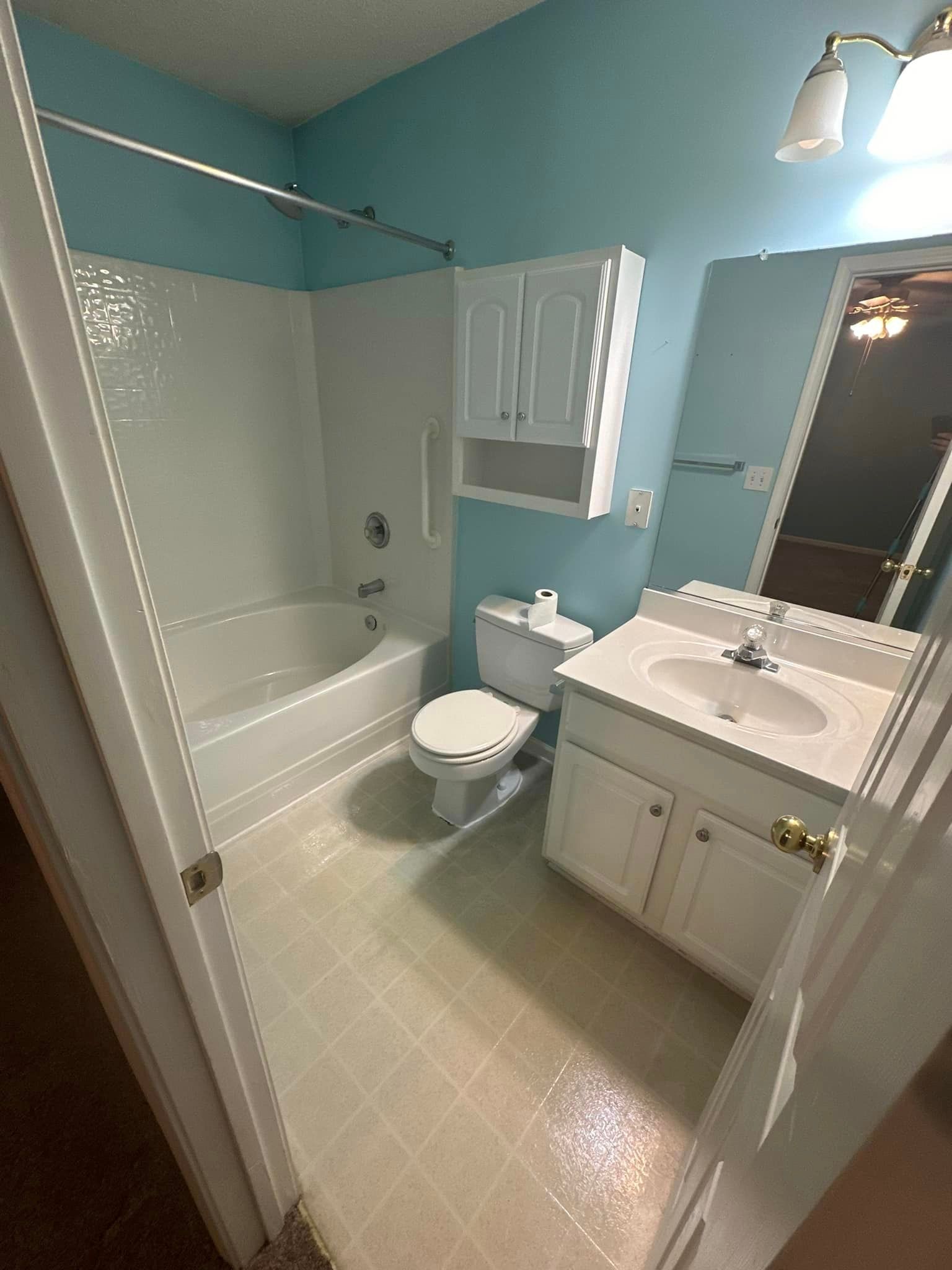 A bathroom with a sink , toilet , bathtub and mirror.