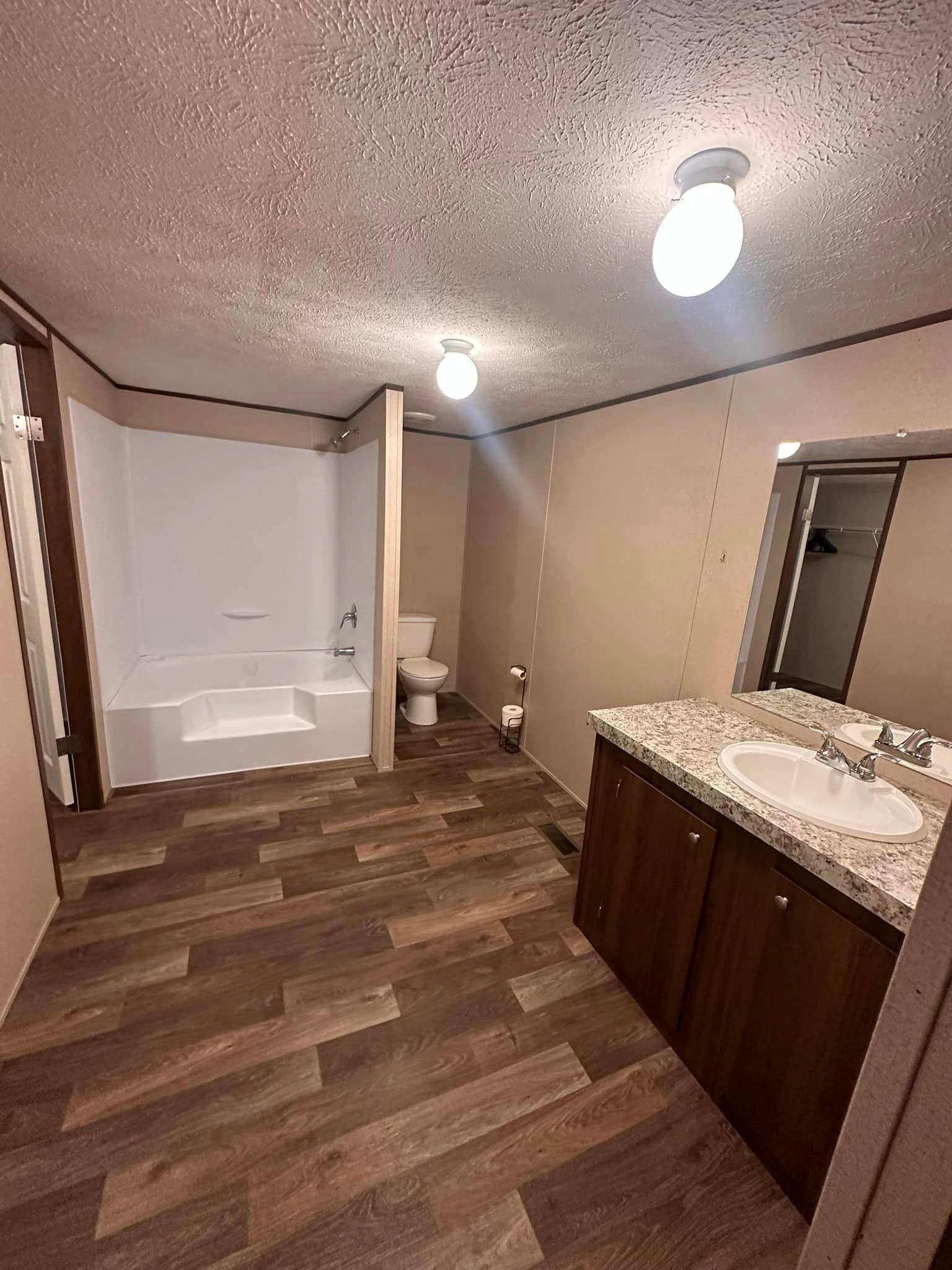 A bathroom with a sink , toilet , bathtub and mirror.