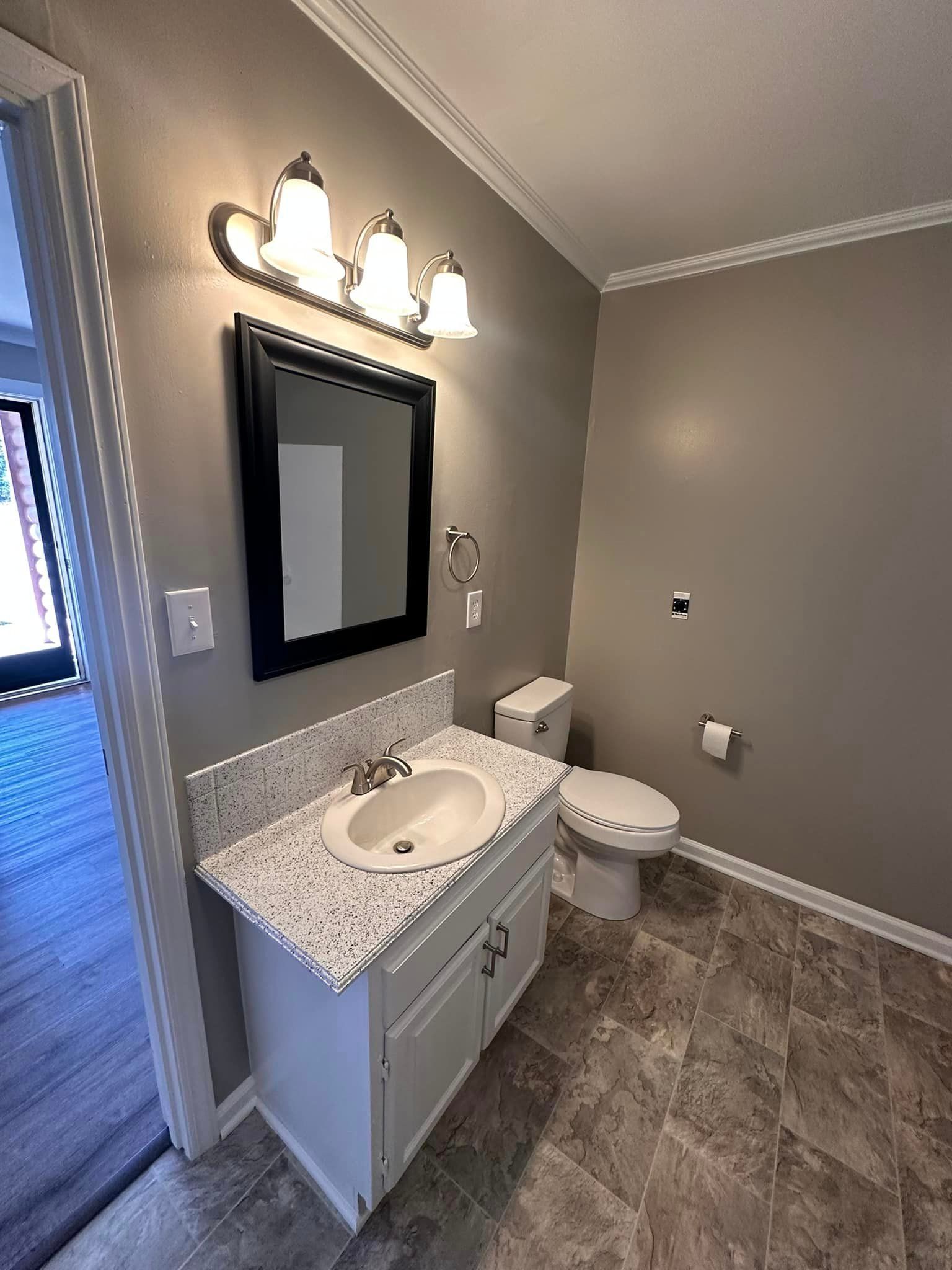 A bathroom with a sink , toilet and mirror.
