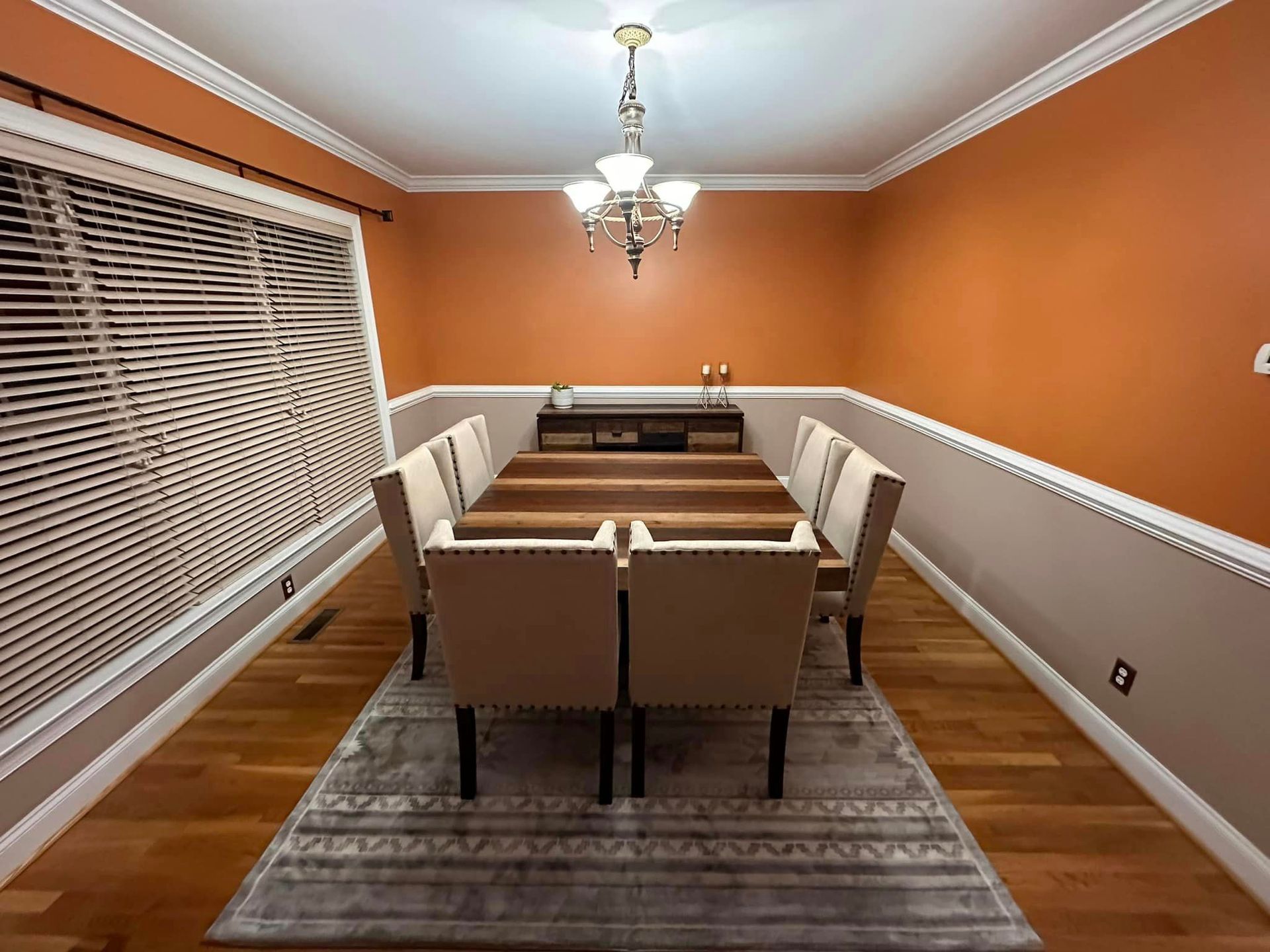 A dining room with a long wooden table and chairs