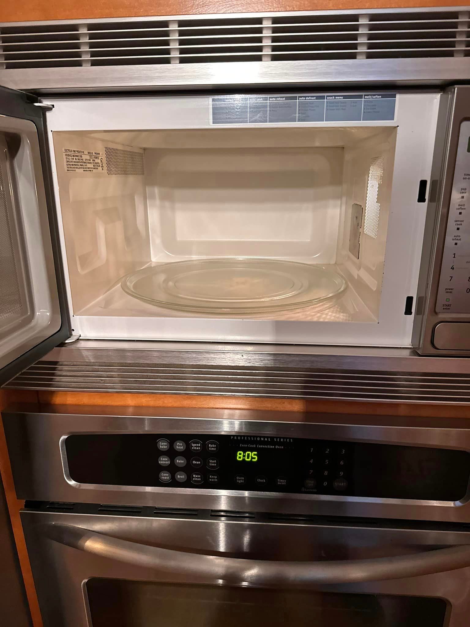 A microwave oven with the door open and a plate in it.