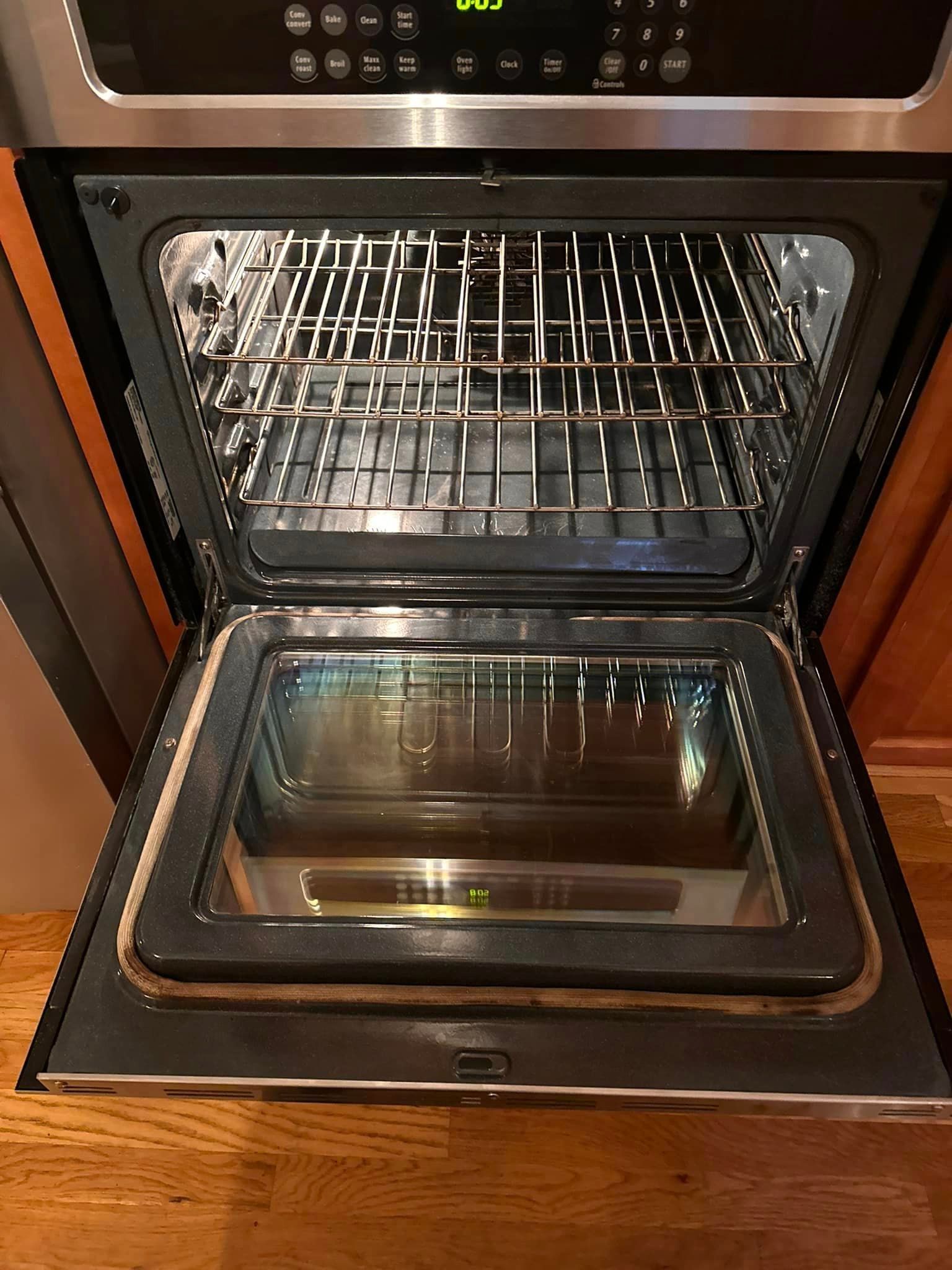 A stainless steel oven with the door open in a kitchen.