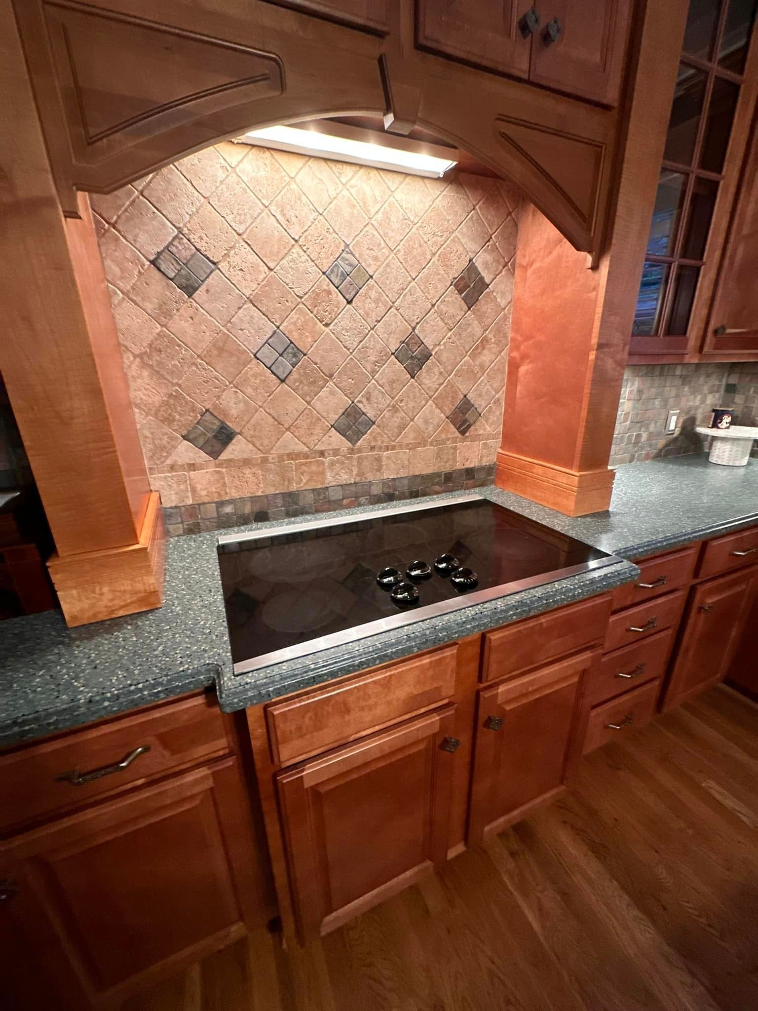 A kitchen with wooden cabinets and a stove top oven.