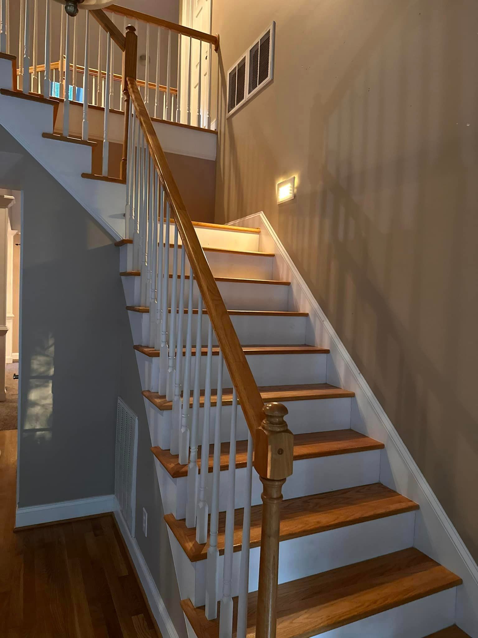 A staircase with wooden steps and a white railing in a house