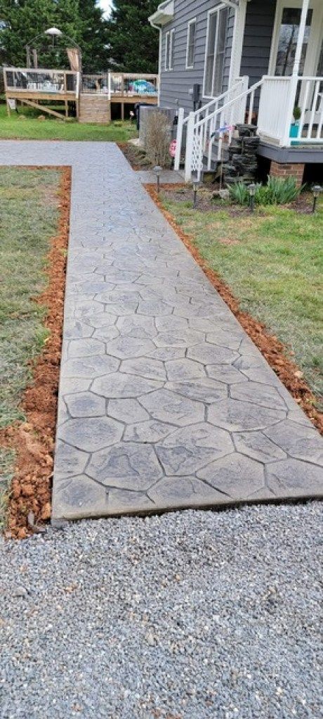 A concrete walkway is being built in front of a house.