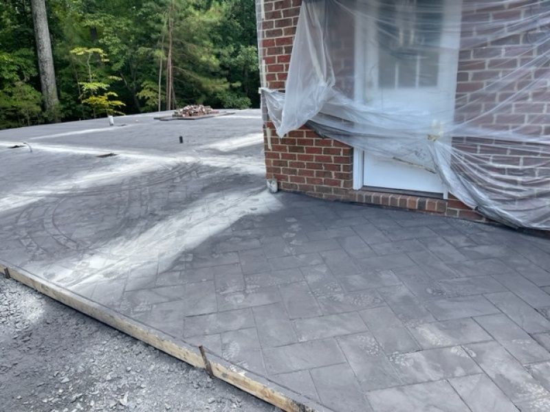 A brick building with a concrete driveway in front of it.