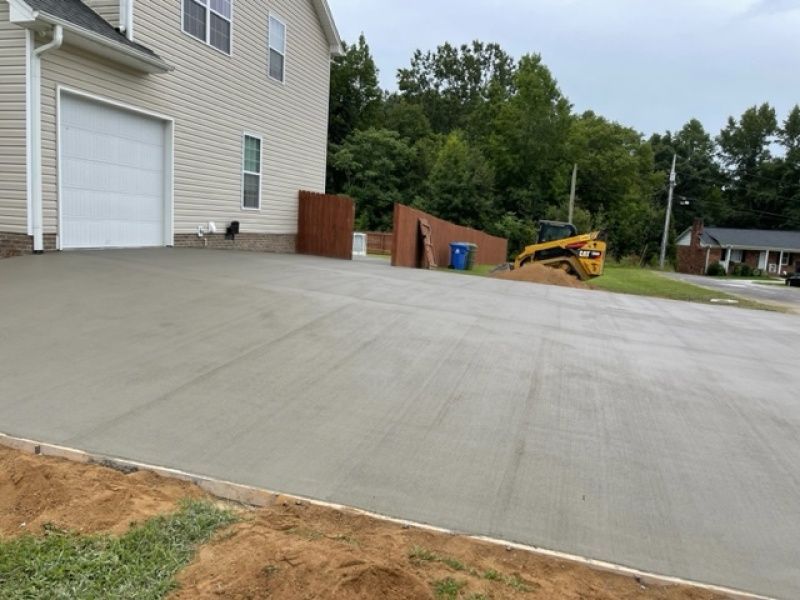 A concrete driveway is being built in front of a house.