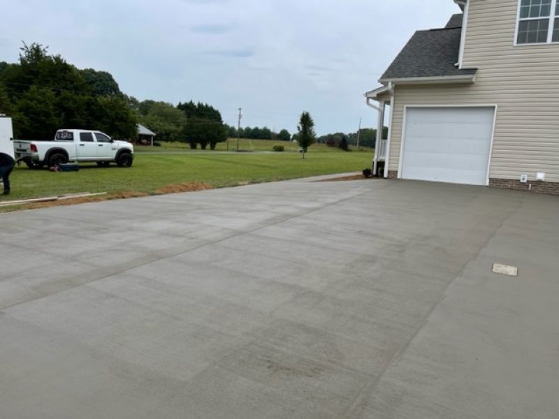 A white truck is parked in a driveway next to a house.