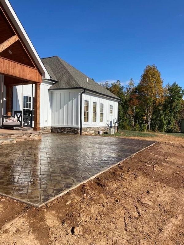 A white house with a brick driveway in front of it.