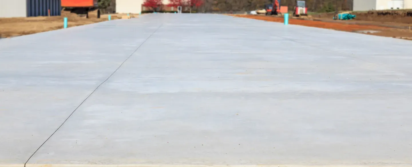 A concrete driveway is being built on a construction site.