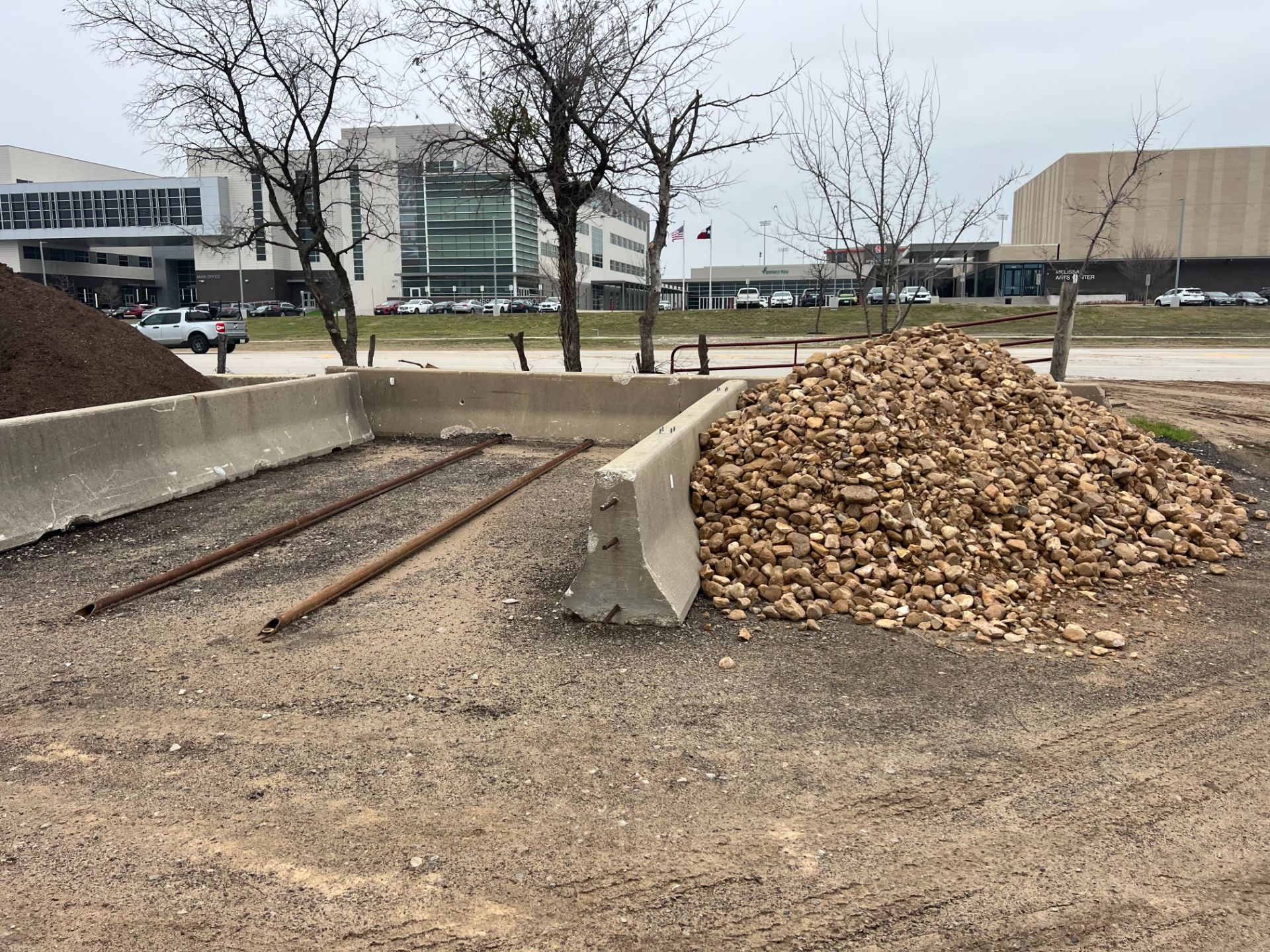 A pile of wood chips is sitting on the ground in a parking lot.