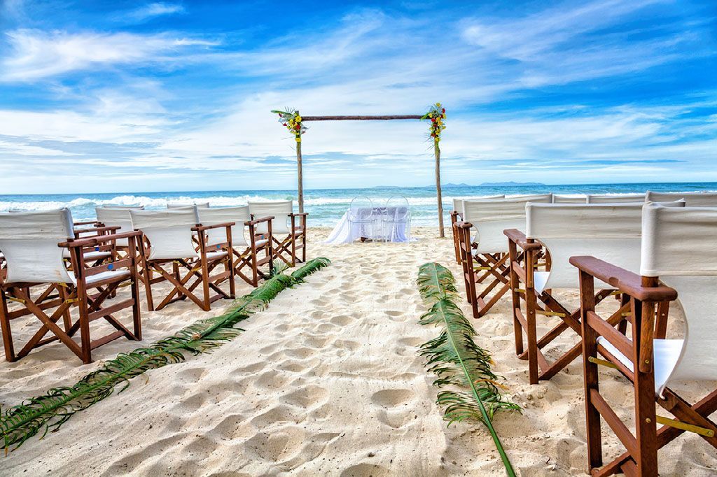 A wedding ceremony is taking place on the beach.