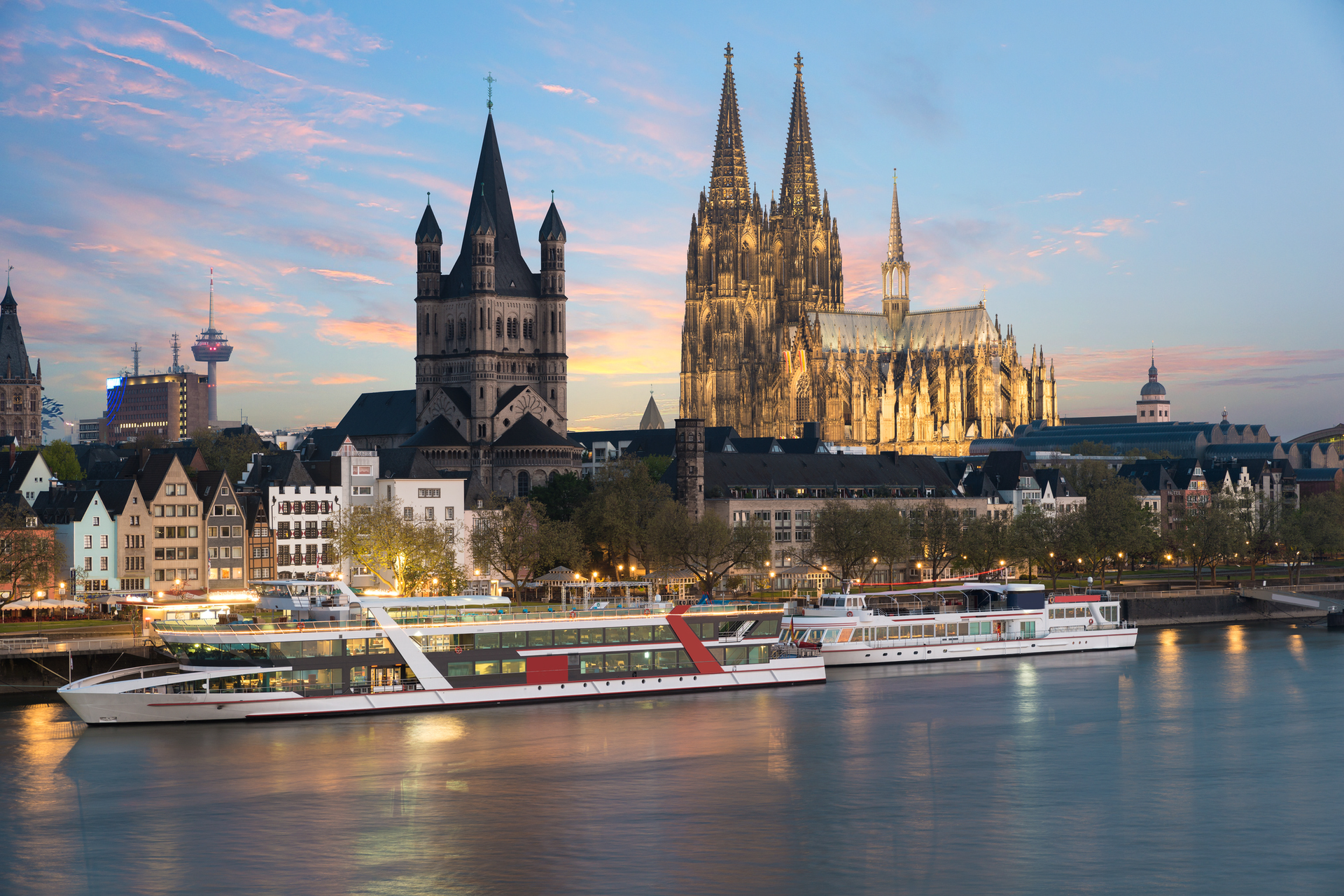 There are many boats in the water in front of a large cathedral.