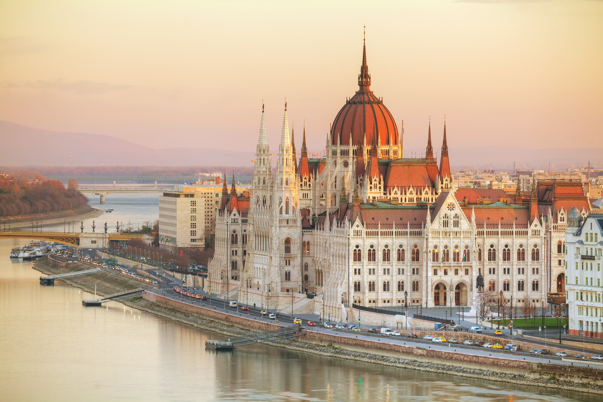An aerial view of the parliament building in hungary with a river in the foreground.