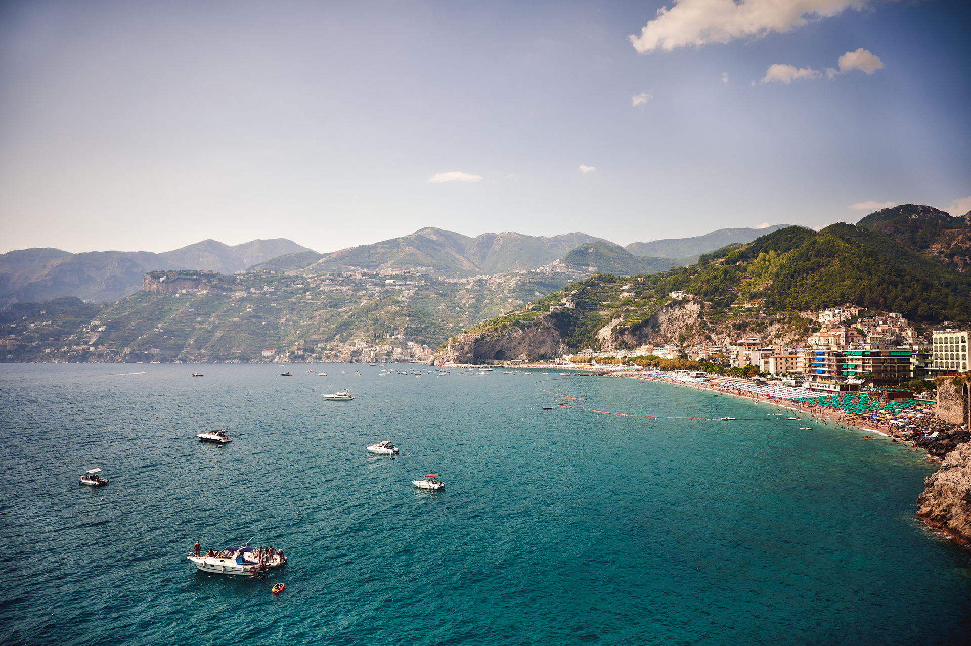 A large body of water with boats in it and mountains in the background.