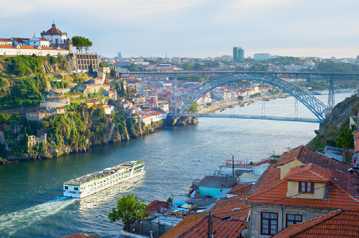 A boat is going down a river with a bridge in the background.