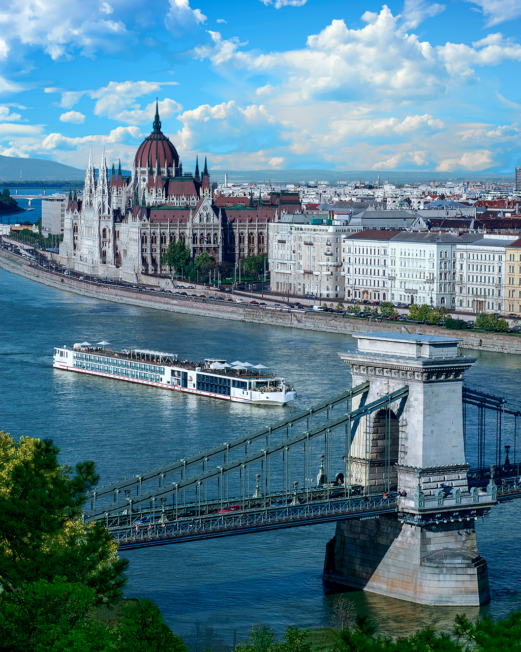 A boat is going under a bridge in front of a city.