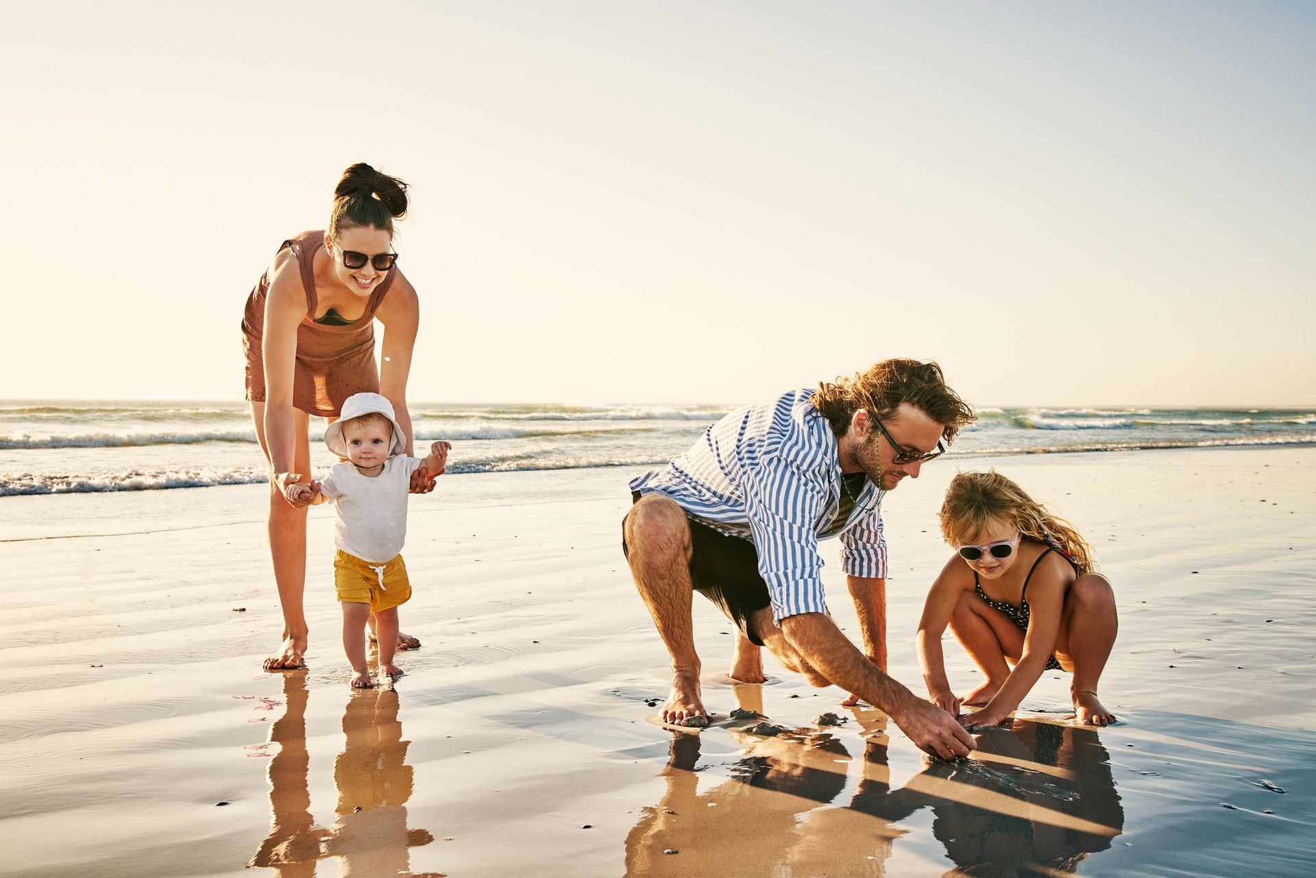 A family is playing in the sand on the beach.
