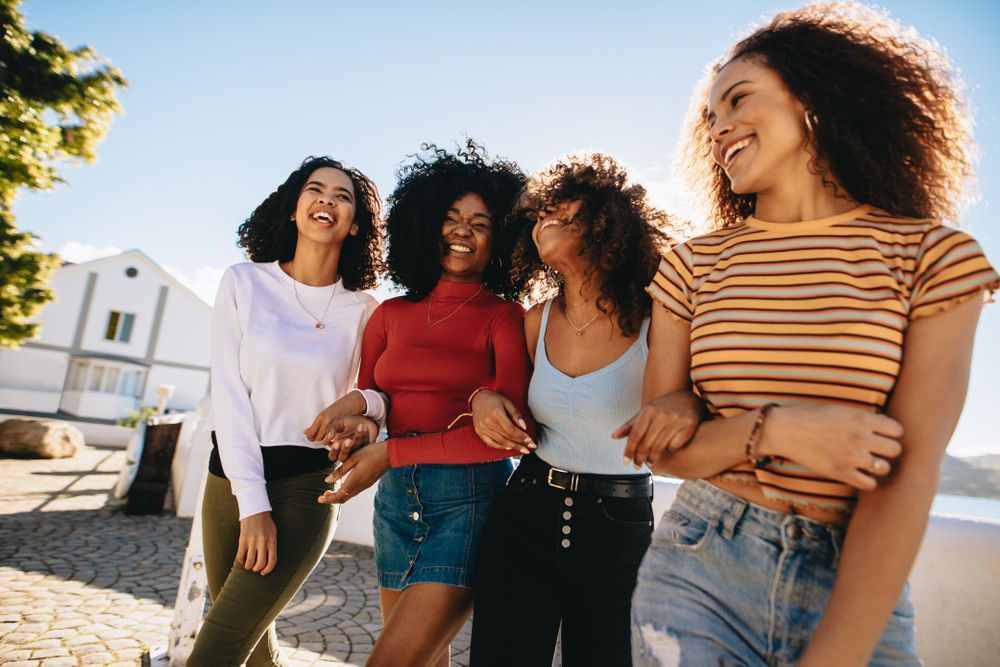 A group of young women are standing next to each other on a sidewalk.