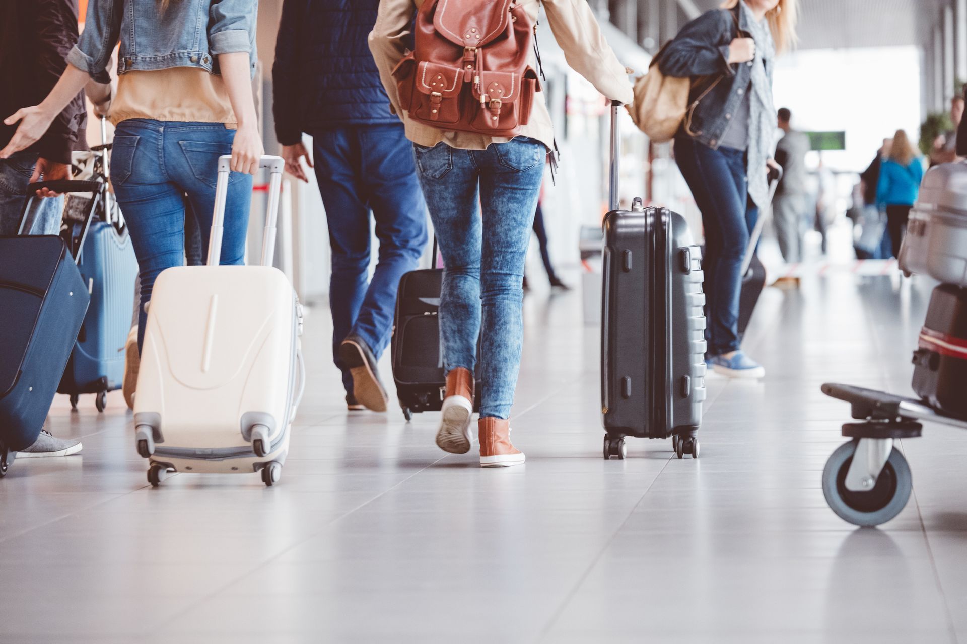 A group of people are walking with luggage at an airport.