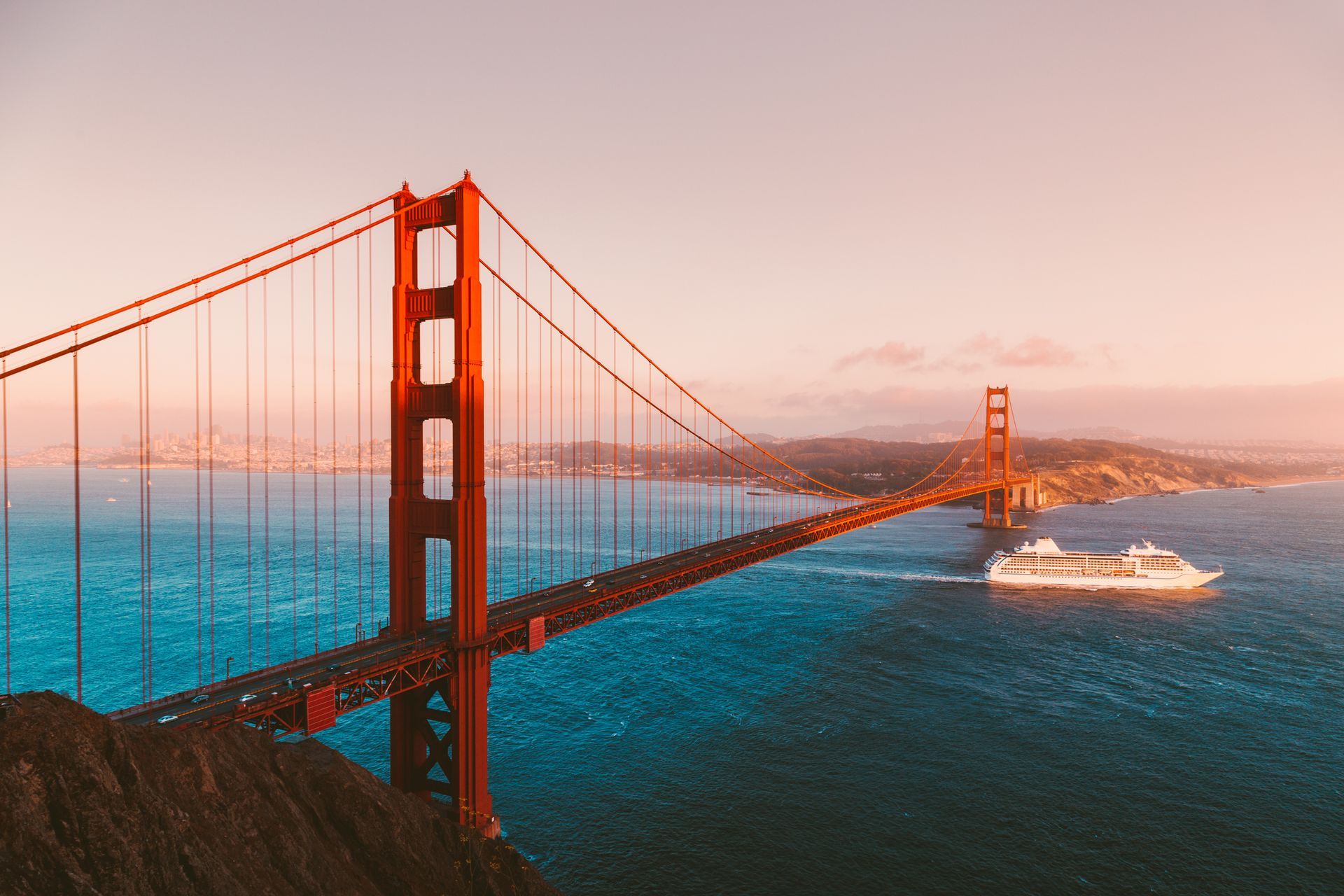 A boat is passing under the golden gate bridge in san francisco.