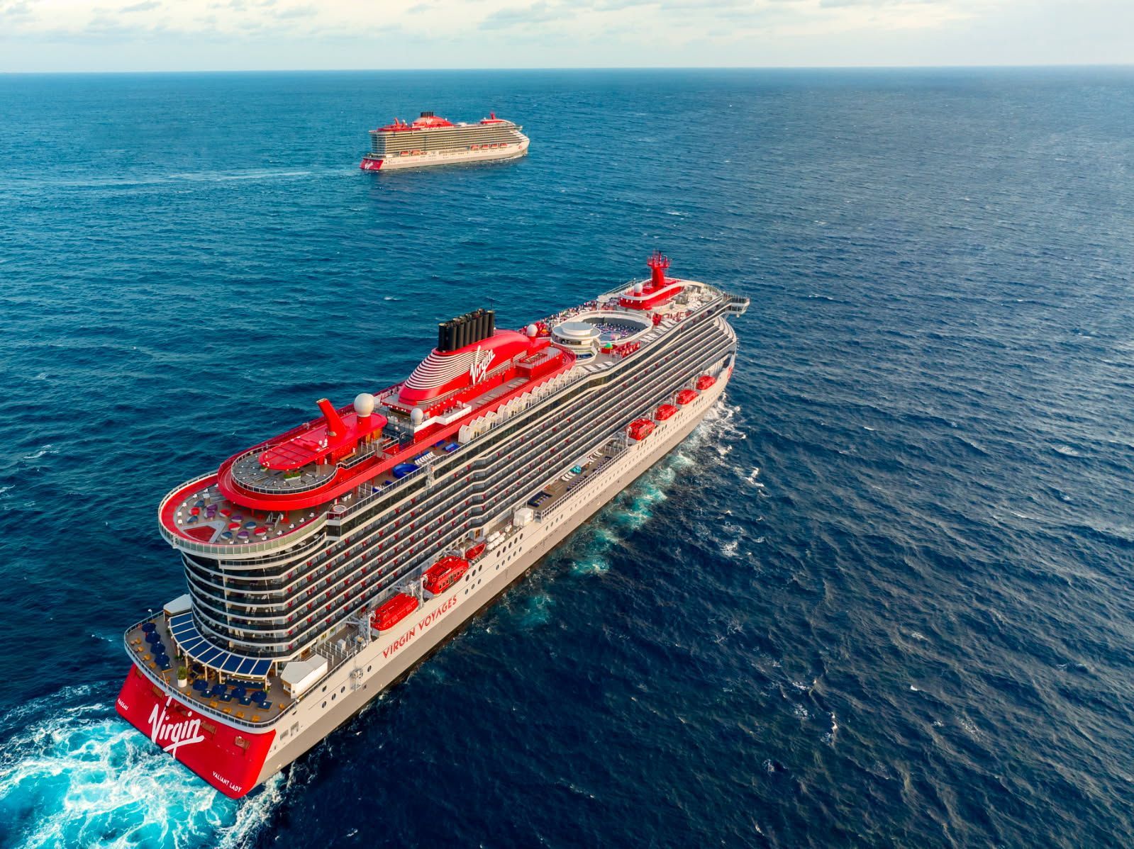 A man is standing on top of a hill looking at the sunset.