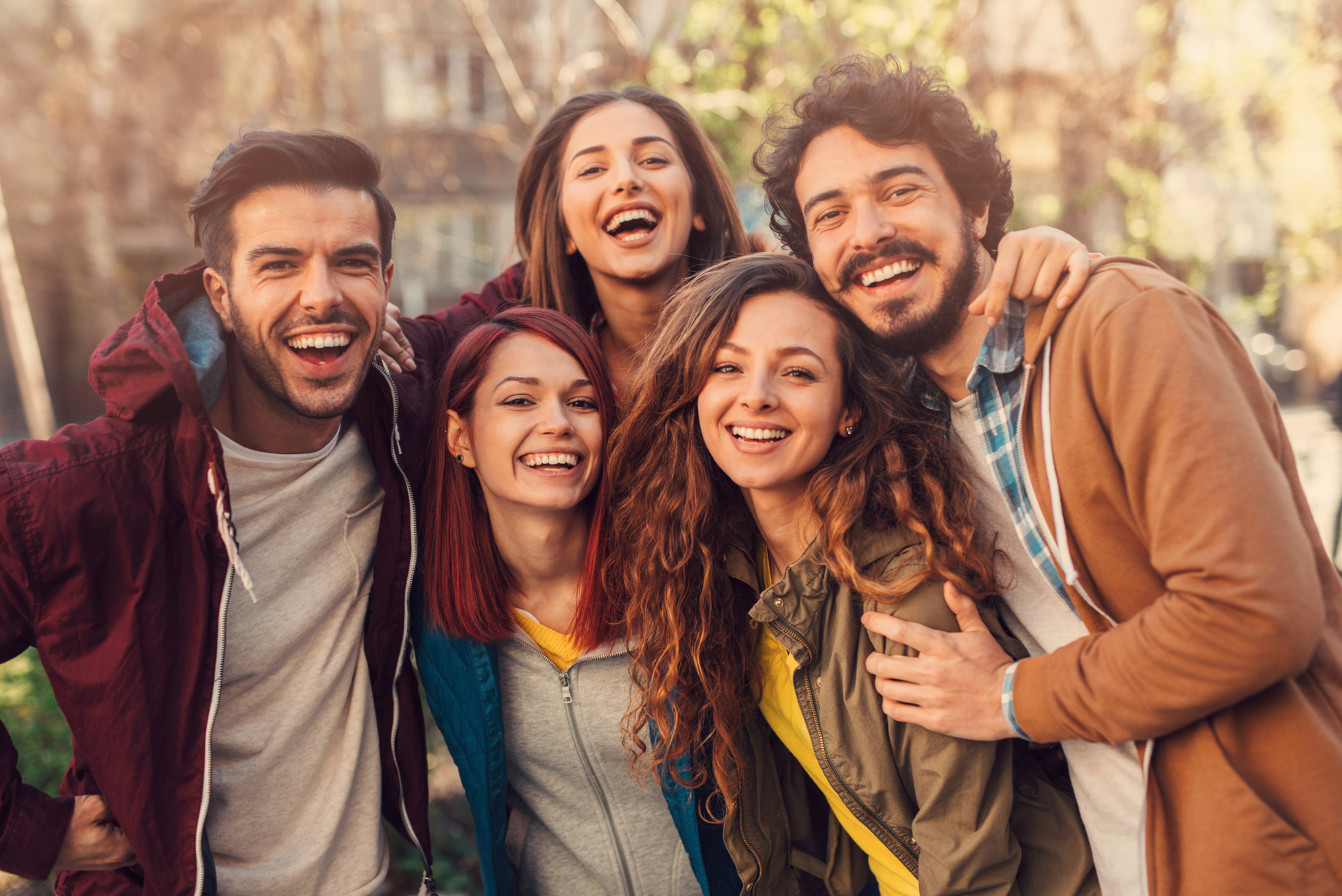 A group of young people are posing for a picture together and smiling.