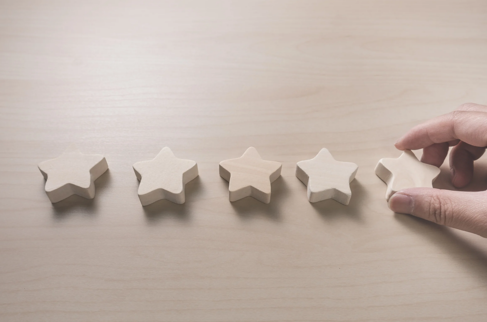 A person is holding a wooden star in their hand.