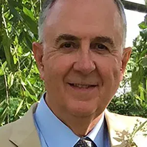 A man in a suit and tie is smiling for the camera.