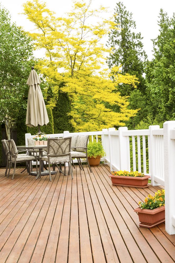 Wooden Deck with Patio Table and White Railing Beside Green Trees in Spring — WJG Built in Wollongbar, NSW