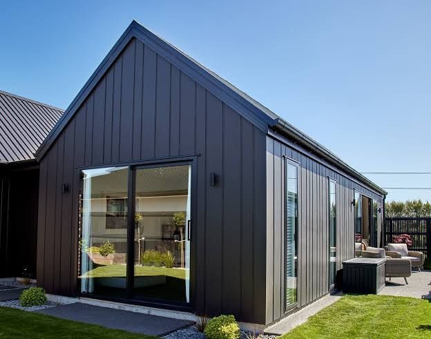 Modern Dark Gray House Exterior with Large Glass Doors and Windows Opening to A Patio and Lawn — WJG Built in Yamba, NSW