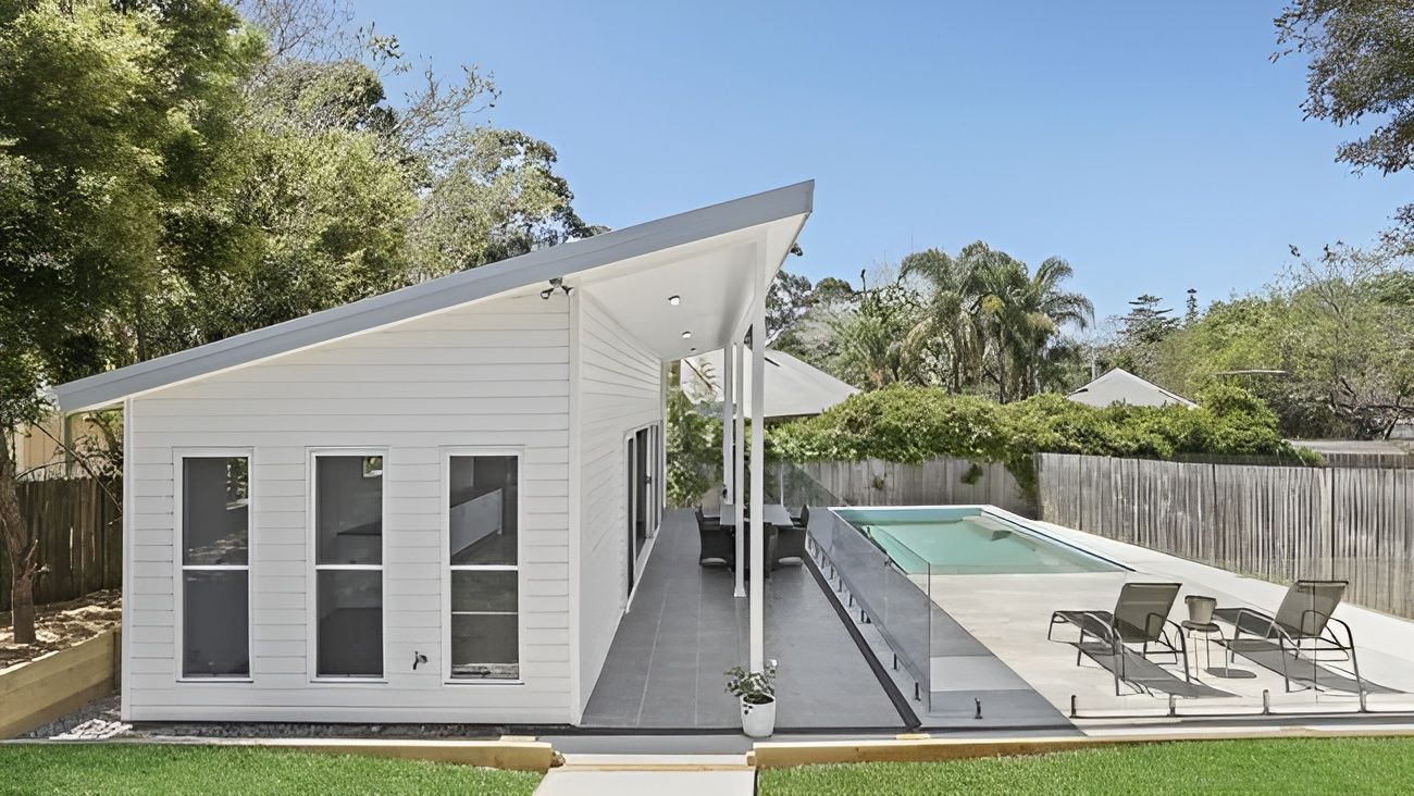 White Modern House Beside a Narrow Pool and Patio with Lounge Chairs — WJG Built in Lismore, NSW