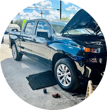 A black truck with the hood up is parked in a parking lot | Cordova Auto Center #4