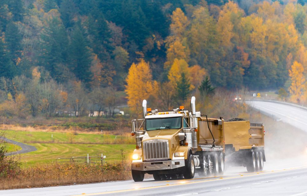 Two Tipper Trailers Running With Turned on Headlight Transporting Commercial Cargo — Container, Machinery & General Freight Transport in Townsville, QLD