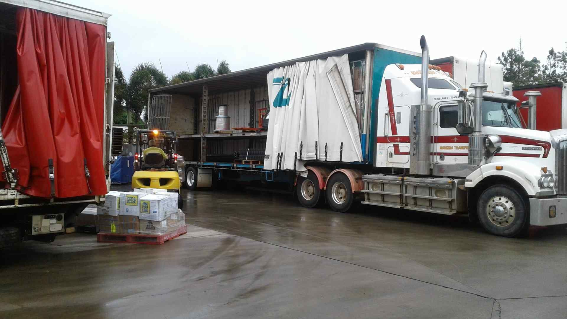 A Truck With a White Tarp on the Side — Reliable Machinery Transport in Mareeba, QLD